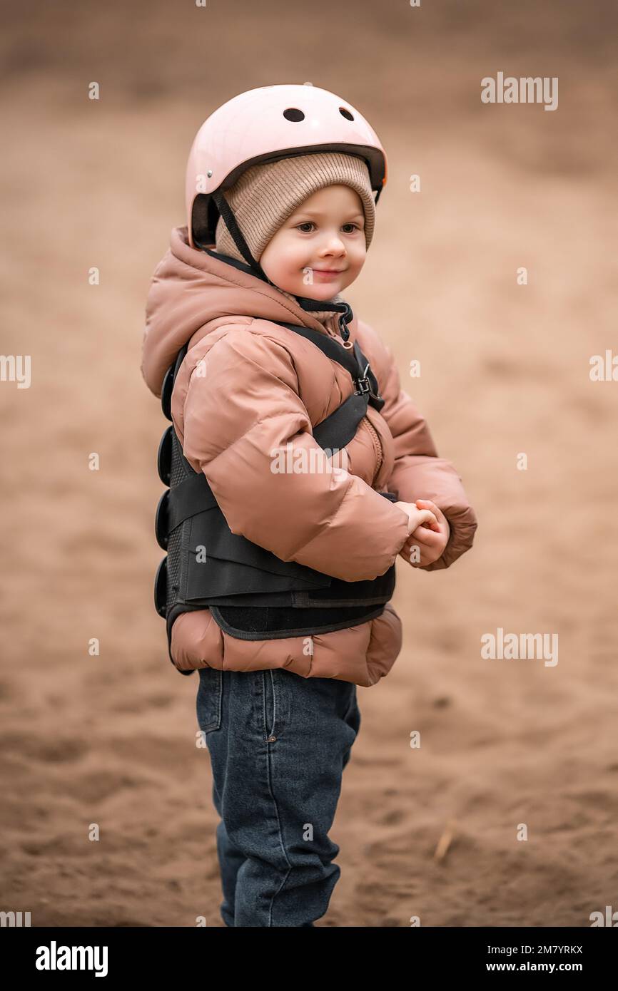 Porträt eines kleinen Mädchens in Schutzjacke und Helm vor dem Reitstunden Stockfoto