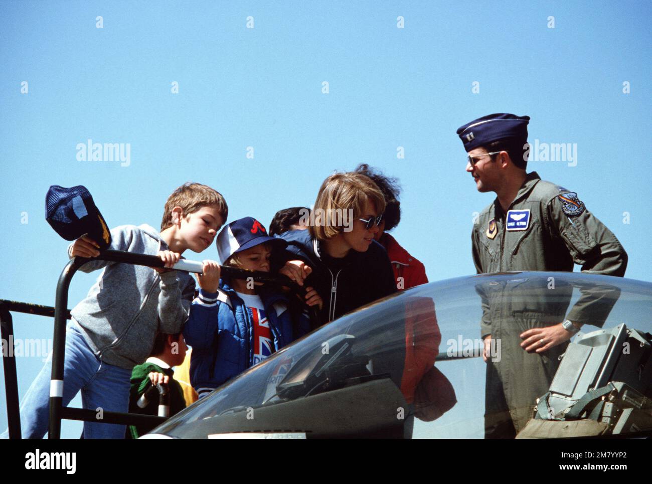 Captain Oltman steht bereit, um Fragen zu beantworten, während Besucher das Cockpit eines F-16 Kampfflugzeugs von Falcon inspizieren. Das Flugzeug wird während einer Zeremonie ausgestellt, bei der der Umbau des taktischen Kampfflugflügels 401. von F-4 Phantom II zu F-16s und der 40. Jahrestag der Einheit begangen wird. Basis: Torrejon Luftwaffenstützpunkt: Spanien (E) Stockfoto