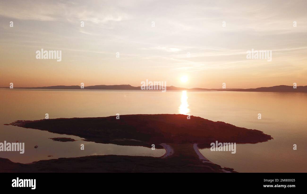 Blick auf die Isle of Jura und die Isle of Islay, Hebriden, Schottland von der Isle of Gigha bei Sonnenuntergang Stockfoto
