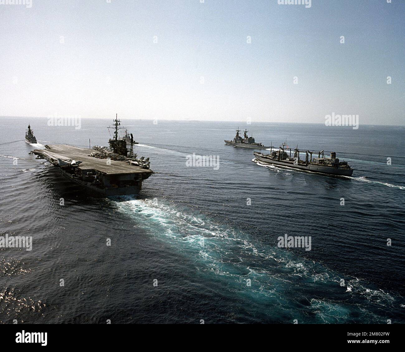 Ein Hafenviertel-Blick aus der Luft auf den Flugzeugträger USS AMERICA (CV-66), der im Einsatz ist, wobei zwei weitere Schiffe seiner Kampfgruppe zugeordnet sind. Land: Indischer Ozean (IOC) Stockfoto