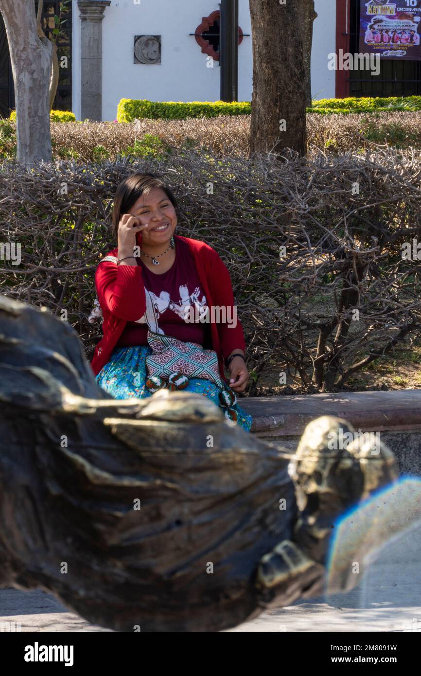 Eine Frau, die am Telefon spricht, in einem traditionellen Kostüm der wixarika huichol-Kultur Stockfoto