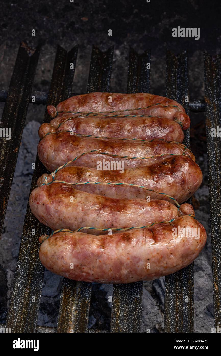 Gegrillte Chorizos auf einem Holzbrett, typische argentinische Würstchen mit gemischtem Schweinefleisch und Rindfleisch. Stockfoto