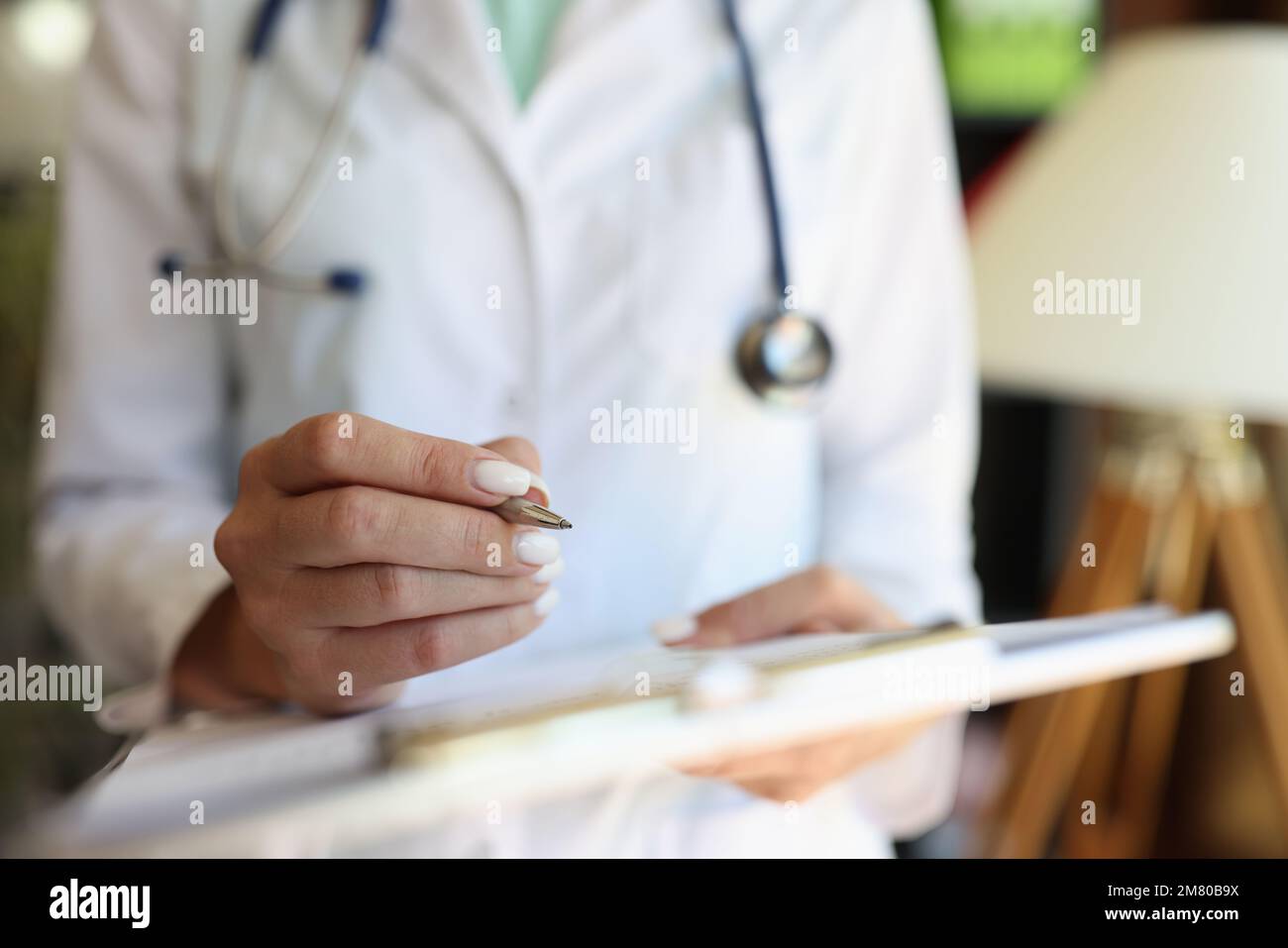 Weibliche Ärztin, die mit medizinischen Formularen und Dokumenten arbeitet, Nahaufnahme. Stockfoto