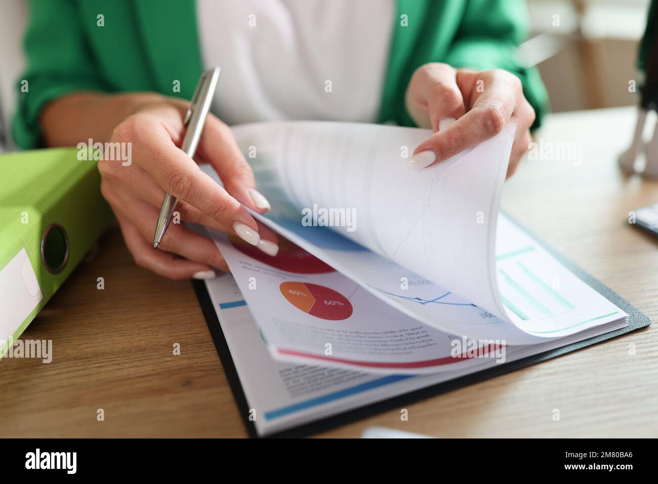 Weibliche Managerin, die mit Finanz- und Marketingdokumenten an ihrem Schreibtisch arbeitet. Stockfoto