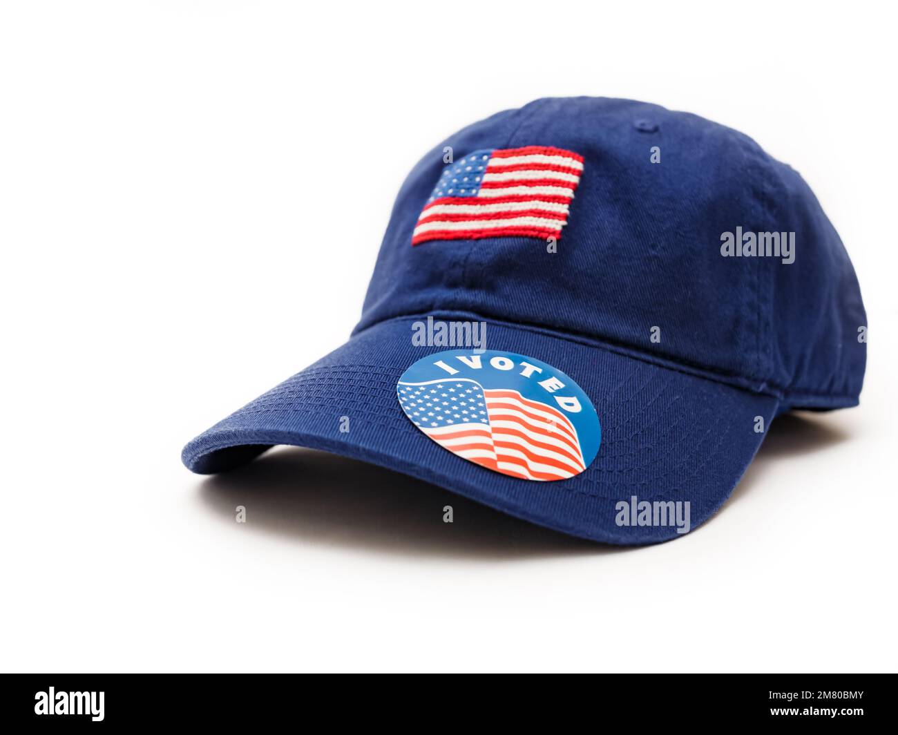Ich habe für einen Aufkleber auf einem patriotischen blauen Baseballhut gestimmt, mit amerikanischer Flagge auf weißem Hintergrund. Stockfoto