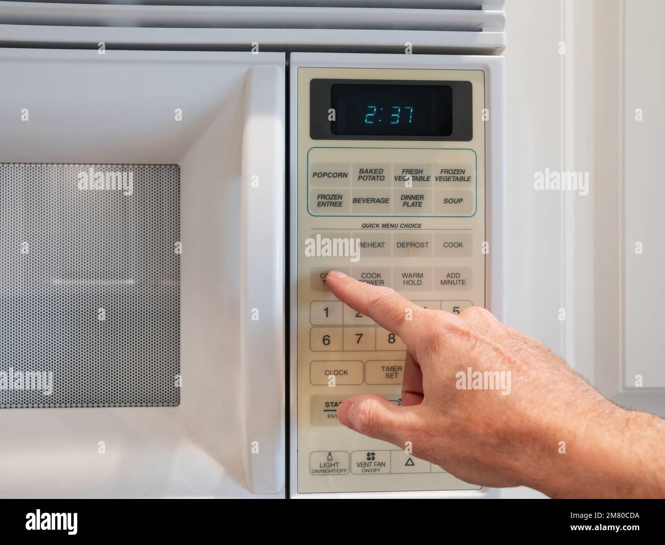 Einstellen der Leistung der Mikrowelle und der Mikrowellendauer zum Kochen oder Aufwärmen über eine digitale Tastatur. Auswählen von Temperatur und Garzeit du Stockfoto