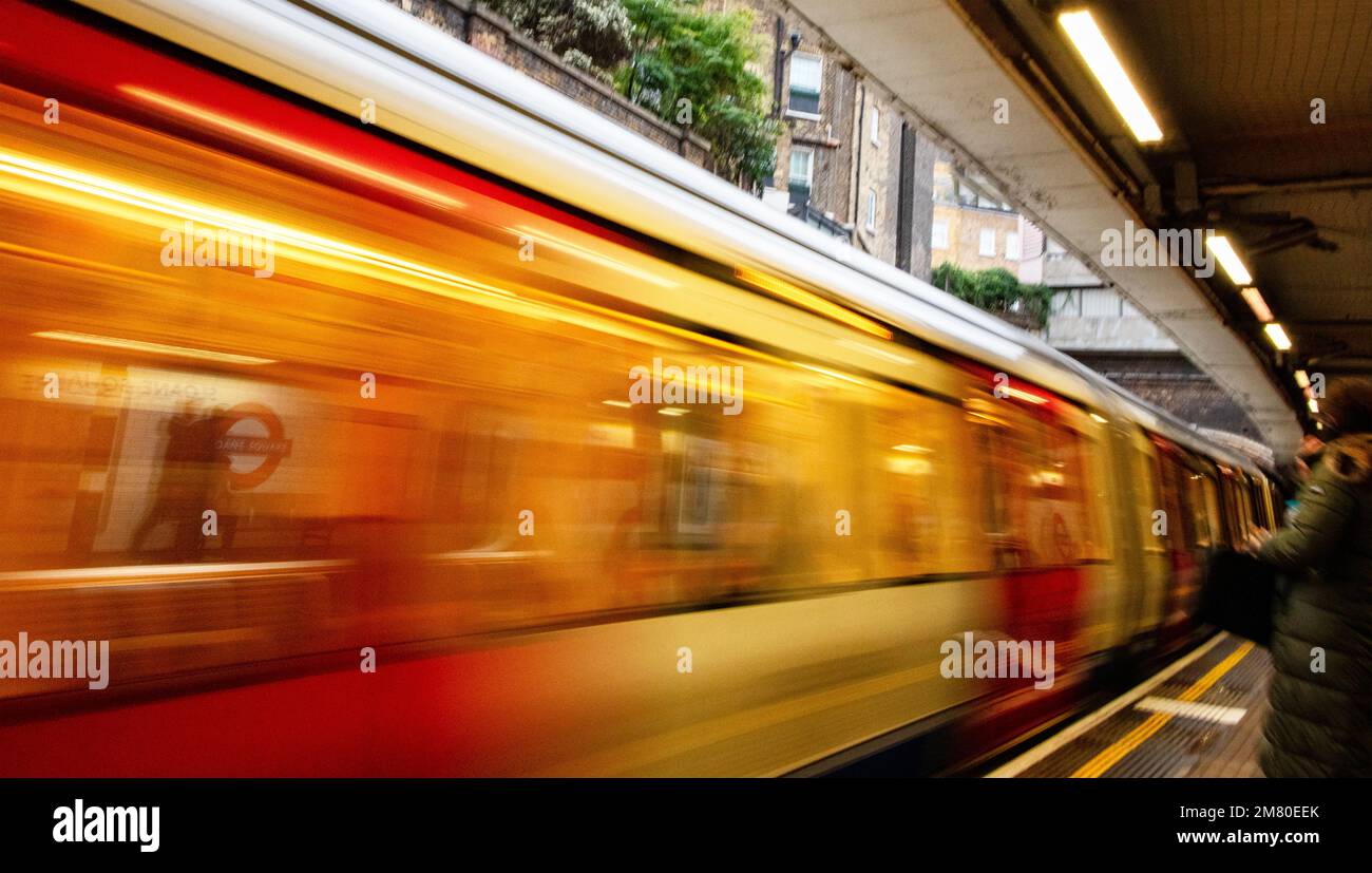 Londoner U-Bahn-Station Sloane Square, betrieben von TFL (Transport for London); die U-Bahn kommt mit hoher Geschwindigkeit an, das Bild verschwamm Stockfoto