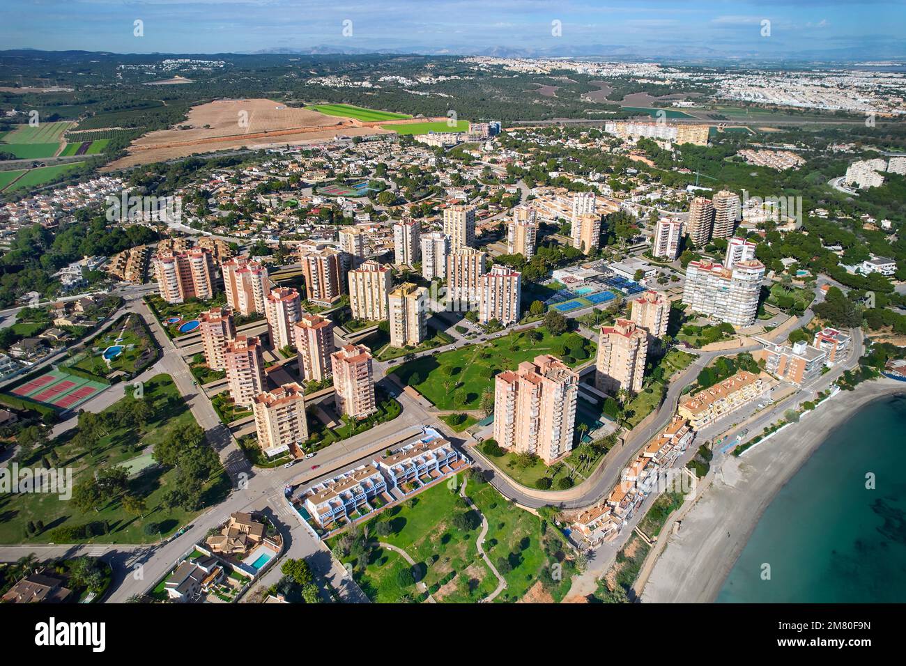 Blick auf die Drohne, Luftaufnahme von Dehesa de Campoamor an sonnigen Tagen mit Wohngebäude und Blick auf das Mittelmeer. Costa Blanca, Alicante. Stockfoto