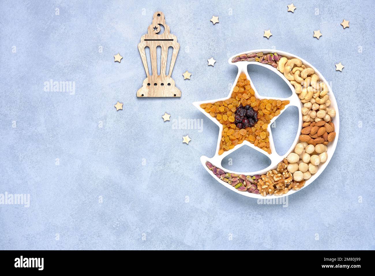 Ramadan-Karäem mit getrockneten Früchten und Nüssen in Form eines Halbmonds. Iftar-Essenskonzept. Draufsicht, Kopierbereich Stockfoto