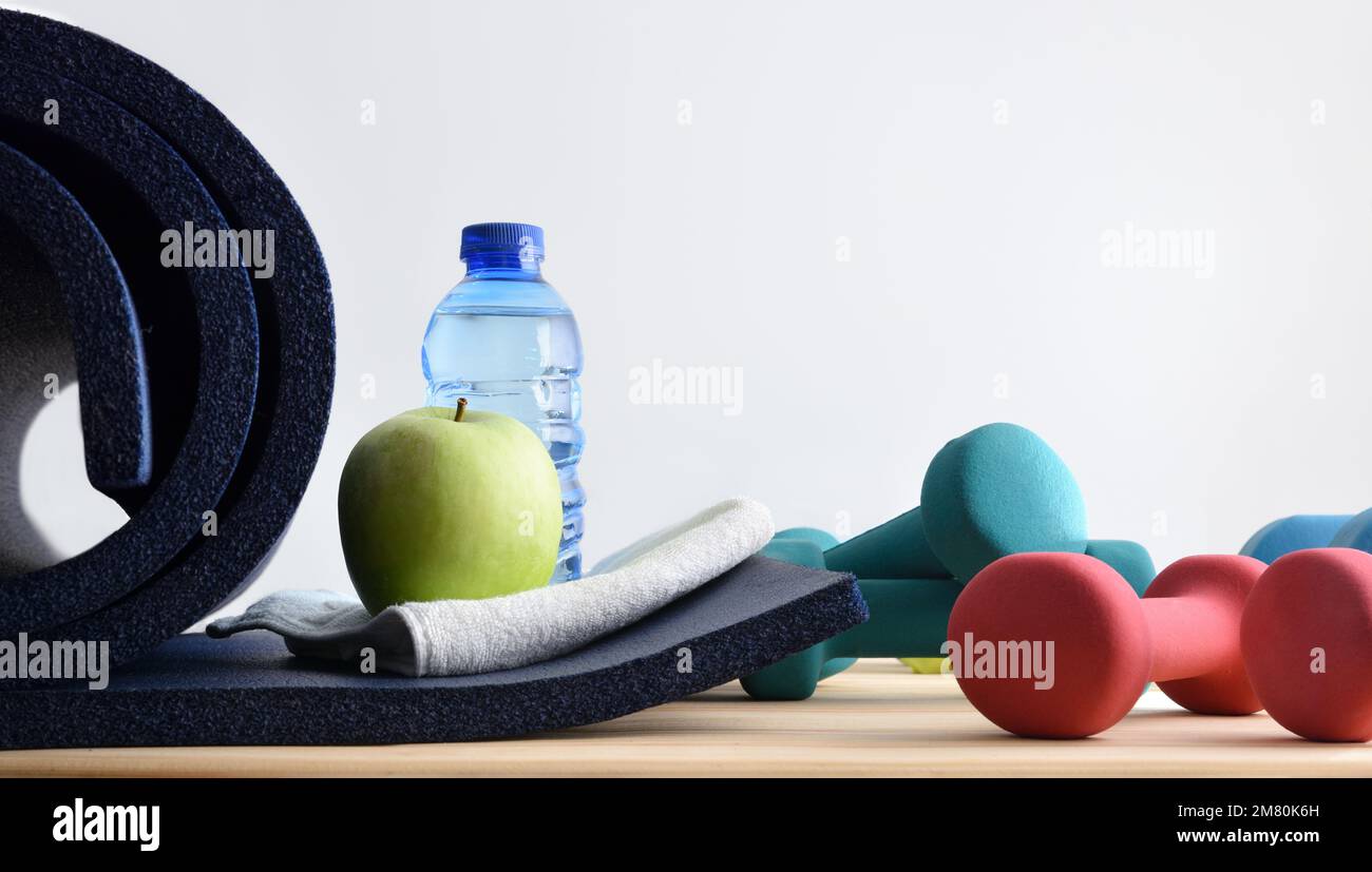 Gesunder Lebensstil mit Heimsportausrüstung auf Holzlatten mit weißem isoliertem Hintergrund. Vorderansicht. Stockfoto