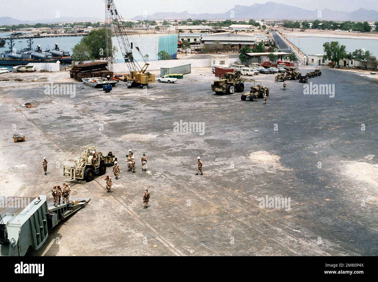 USA Die Ausrüstung des Marine Corps wird vom Containerschiff SS LYRA während der Übung Eastern Wind '83, der amphibischen Landephase von Übung Bright Star '83, entladen. Oben links sind zwei schnelle Angriffsschiffe der Klasse Osa II der somalischen Marine (ehemals sowjetisch) zu sehen. Betreff Operation/Serie: OSTWIND '83BRIGHT STERNE '83 Basis: Berbera Land: Somalia (SOM) Stockfoto