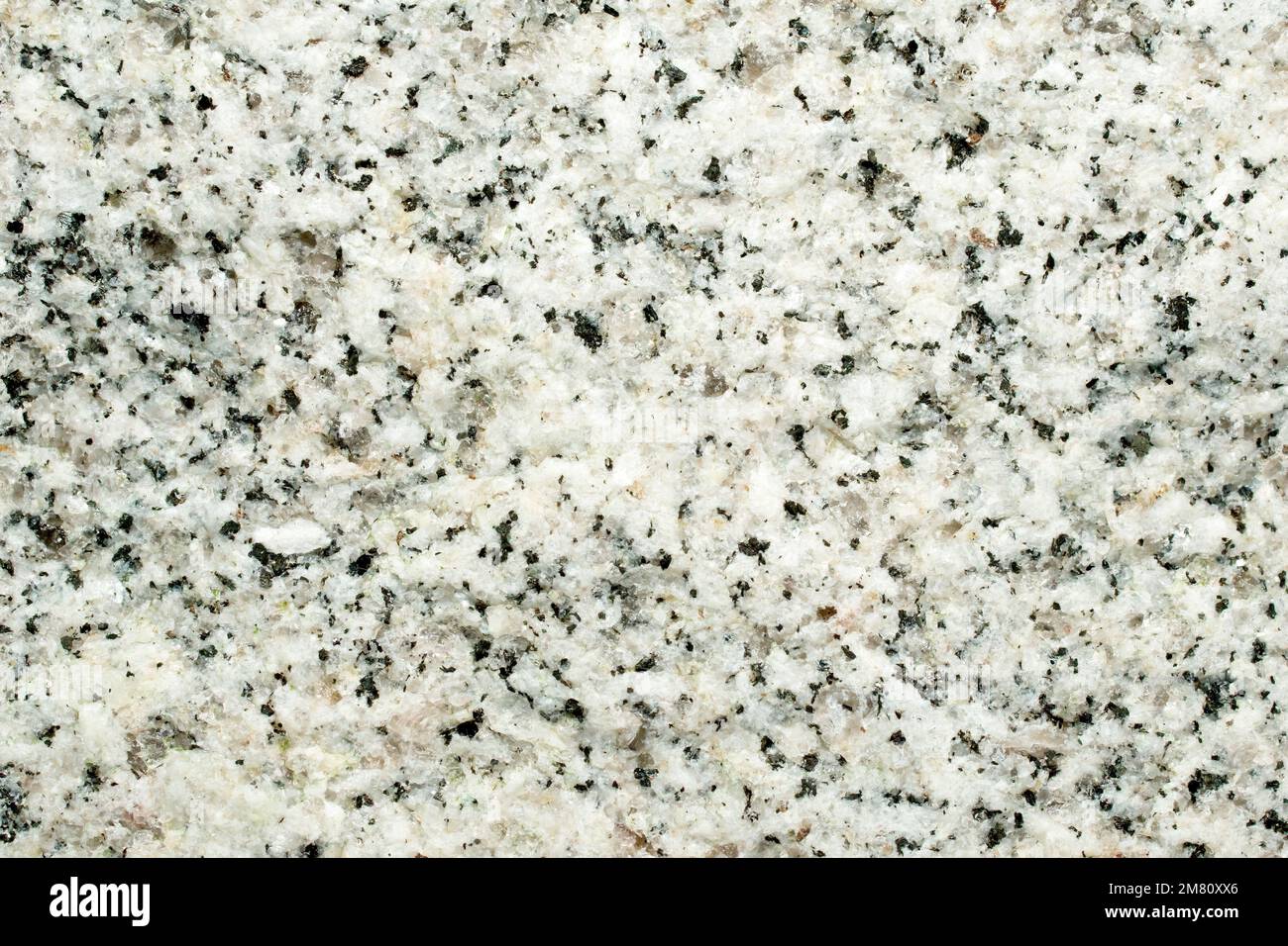 Nahaufnahme der kristallinen Struktur eines Granitstücks, eines grobkörnigen, magneösen Felsens aus Quarz, Feldspat und Glimmer. Stockfoto