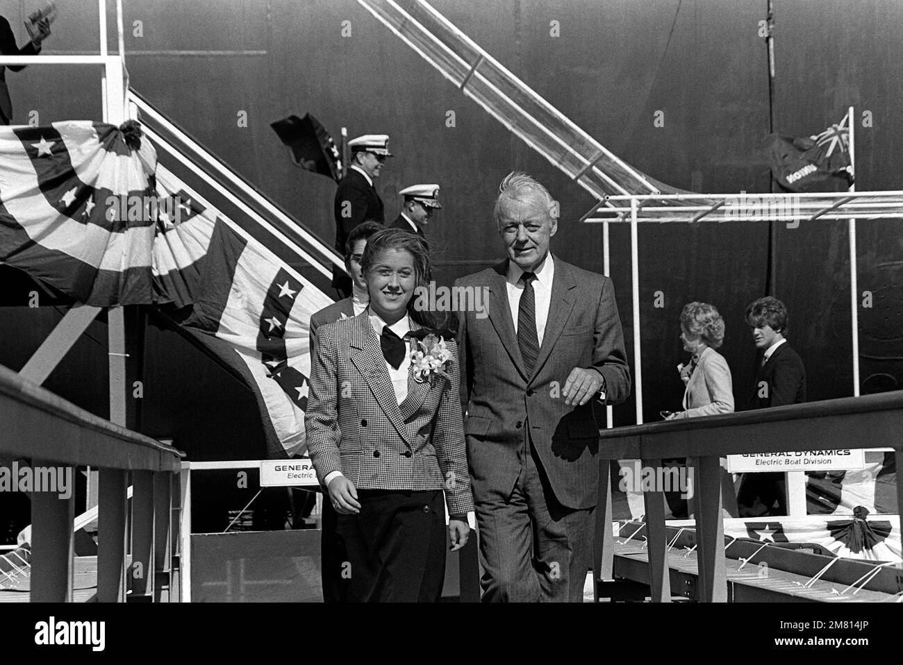 David S. Lewis, Vorstandsvorsitzender der General Dynamics Corp., geht mit Anna Marie Jackson, Sponsor des nuklearbetriebenen strategischen Raketen-U-Boots HENRY M. JACKSON (SSBN-730), zum Abschluss der Abschusszeremonie des Schiffes spazieren. Miss Jackson ist die Tochter des verstorbenen Senders Henry M. Jackson, D-Washington. Basis: Croton Bundesstaat: Connecticut (CT) Land: Vereinigte Staaten von Amerika (USA) Stockfoto