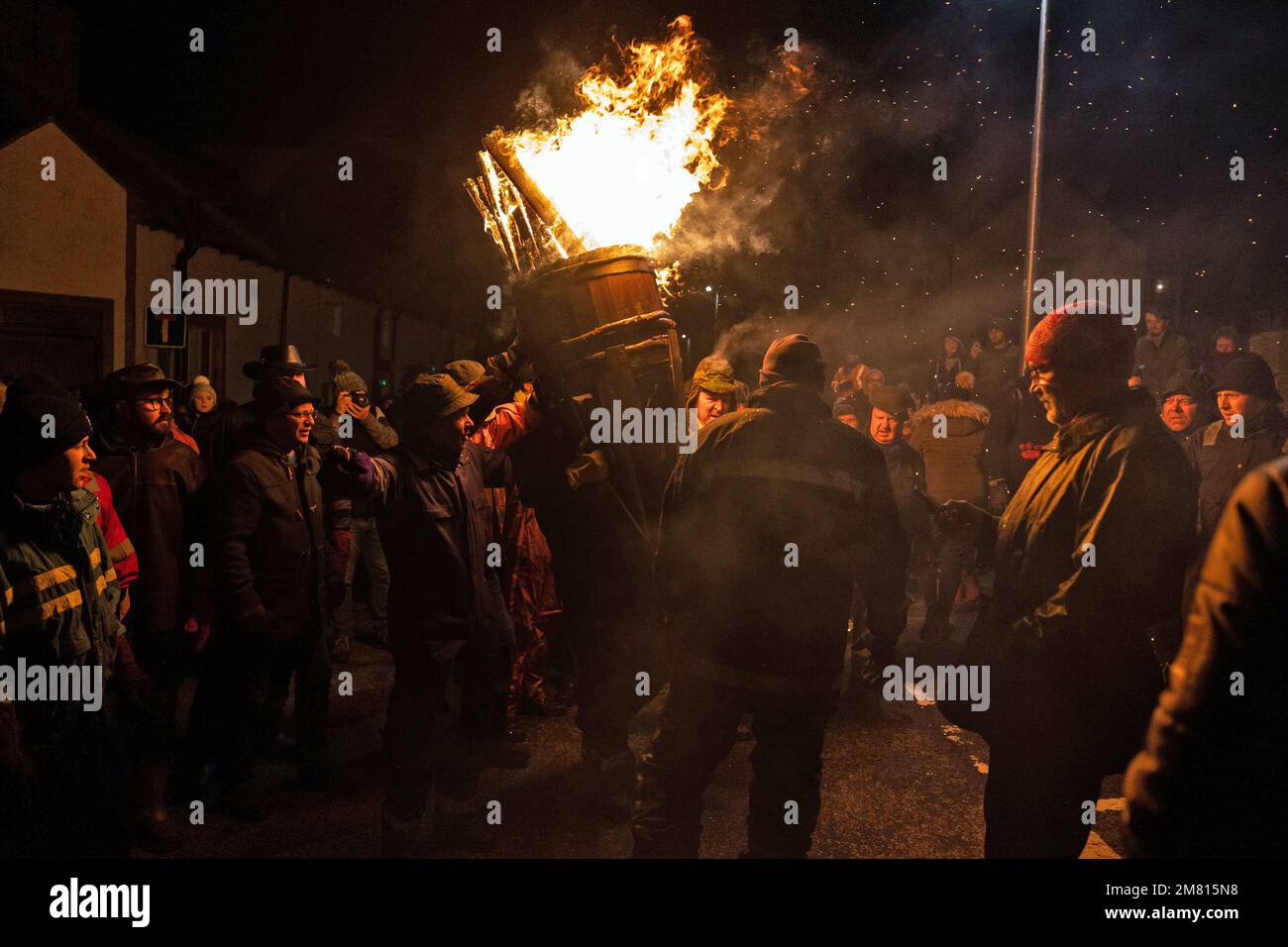 Die Menschen tragen ein brennendes Fass Teer während der Burning of the Clavie, ein 