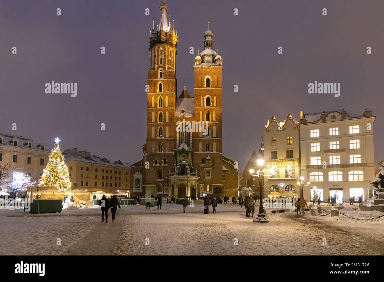 Basilika St. Marys Krakau im Dunkeln beleuchtet; Krakauer Marktplatz im Winterschnee zu Weihnachten, Krakauer Altstadt, Krakau Polen Stockfoto