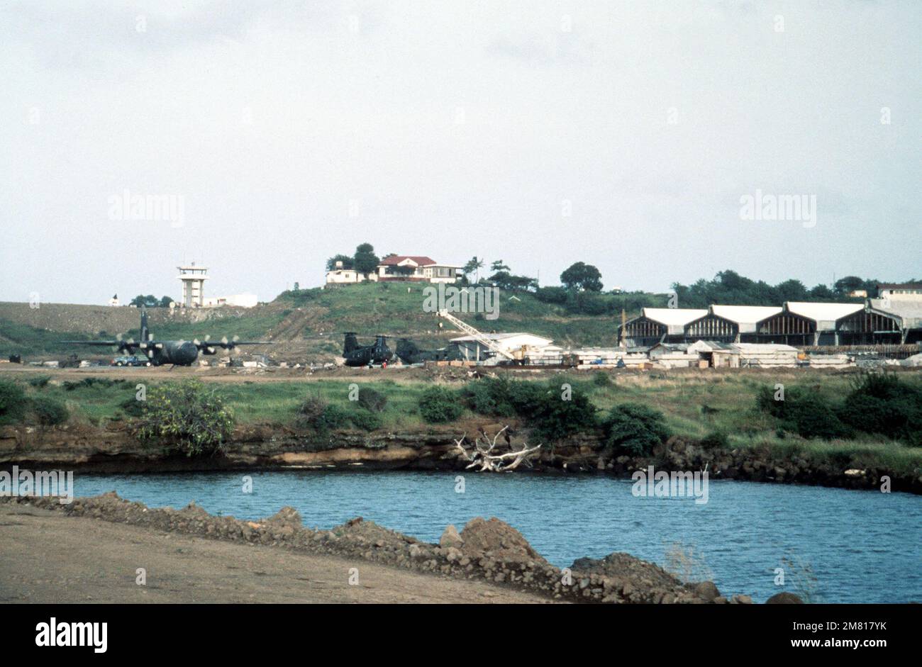 Ein getarntes C-130 Hercules-Flugzeug, Left, und zwei CH-46-Hubschrauber werden von US-Militärpersonal während der Evakuierung von amerikanischem Personal von der Insel eingesetzt. Basis: Point Salines Land: Grenada (GRD) Stockfoto