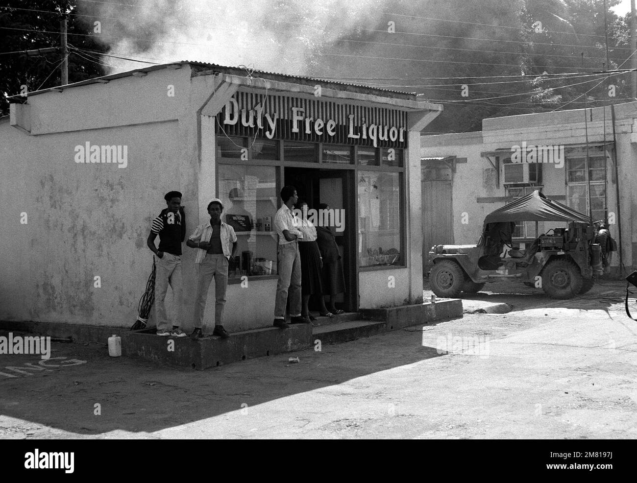 Die Grenadier stehen vor einem Duty-Free-Spirituosenladen und beobachten Aktivitäten während der multifunktionalen, multinationalen Operation URGENT WUT. Betreff Betrieb/Serie: URGENT FURY Country: Grenada (GRD) Stockfoto
