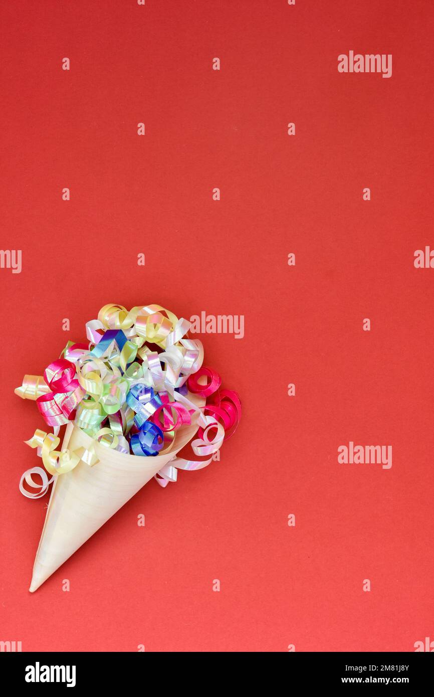 Papiermembran mit farbenfrohen Partytänzern auf rotem Hintergrund. Stockfoto