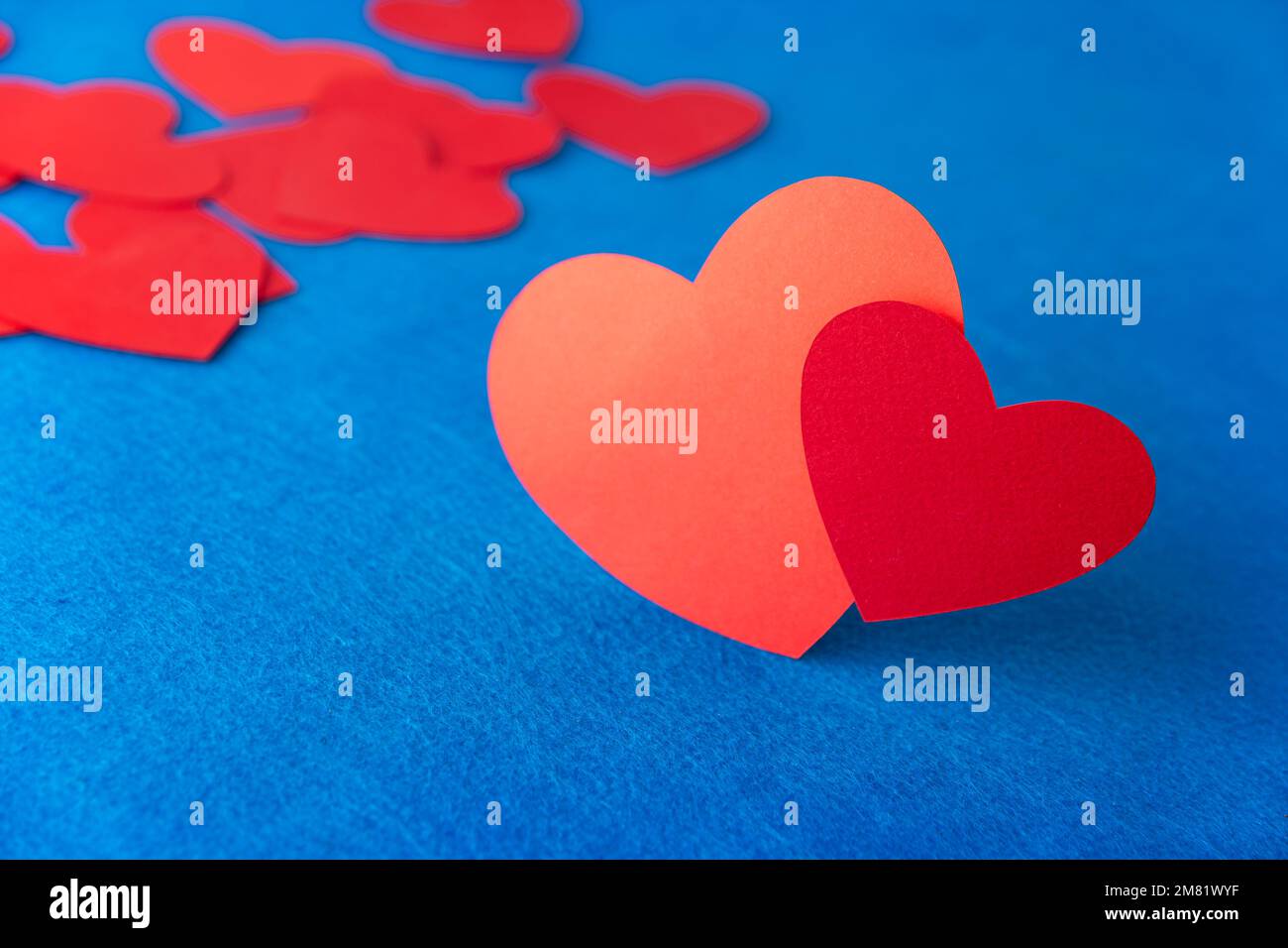 Rotes Papierherz auf blauem strukturiertem Hintergrund mit Kopierbereich. Love Concept Image. Valentinstag, Muttertag, Geburtstagskarten, Einladungen Stockfoto