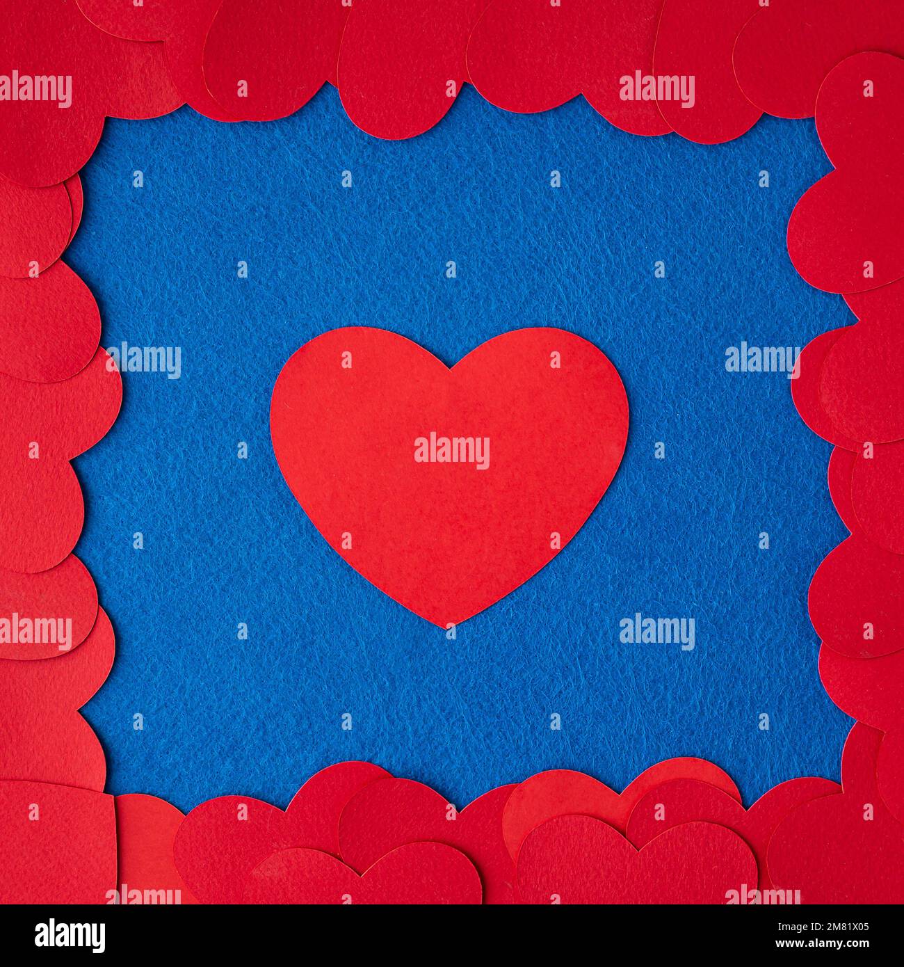 Rote Papierherzen auf blauem strukturiertem Hintergrund mit Kopierbereich. Love Concept Image. Valentinstag, Muttertag, Geburtstagskarten, Einladungen Stockfoto