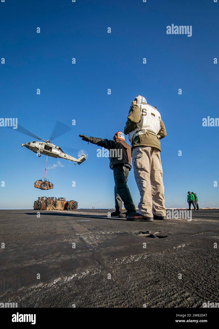 230108-N-EL850-1589 IONISCHES MEER (8. Januar 2023) Ein Matrose, der dem Flugzeugträger der Nimitz-Klasse USS George H.W. zugewiesen wurde Bush (CVN 77) signalisiert an einen MH-60s Nighthawk Helikopter, der an Helicopter Sea Combat Squadron (HSC) 5 angeschlossen ist, während einer Wiederauffüllung auf See mit dem Versorgungsschiff USNS Arctic (T-AOE 8), 8. Januar 2023. Carrier Air Wing (CVW) 7 ist die offensive Luft- und Streikkomponente der Carrier Strike Group (CSG) 10 und der George H.W. Buchse CSG. Die Geschwader von CVW-7 sind Strike Fighter Squadron (VFA) 143, VFA-103, VFA-86, VFA-136, Carrier Airborne Early Warning Squadron (V Stockfoto