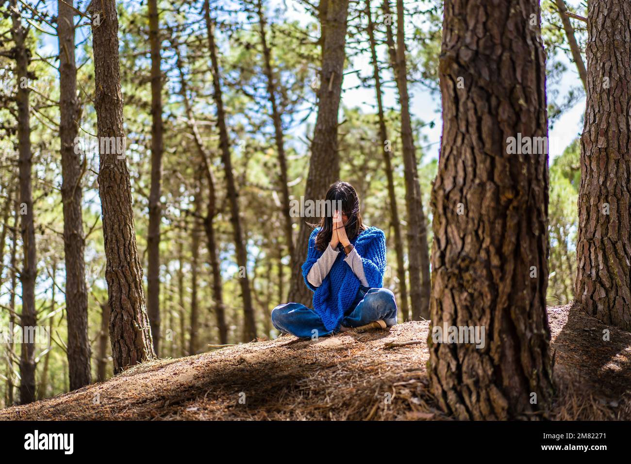 Eine Frau, die sich die Hände im Wald zusammenschlägt. Namaste-Pose. Stockfoto