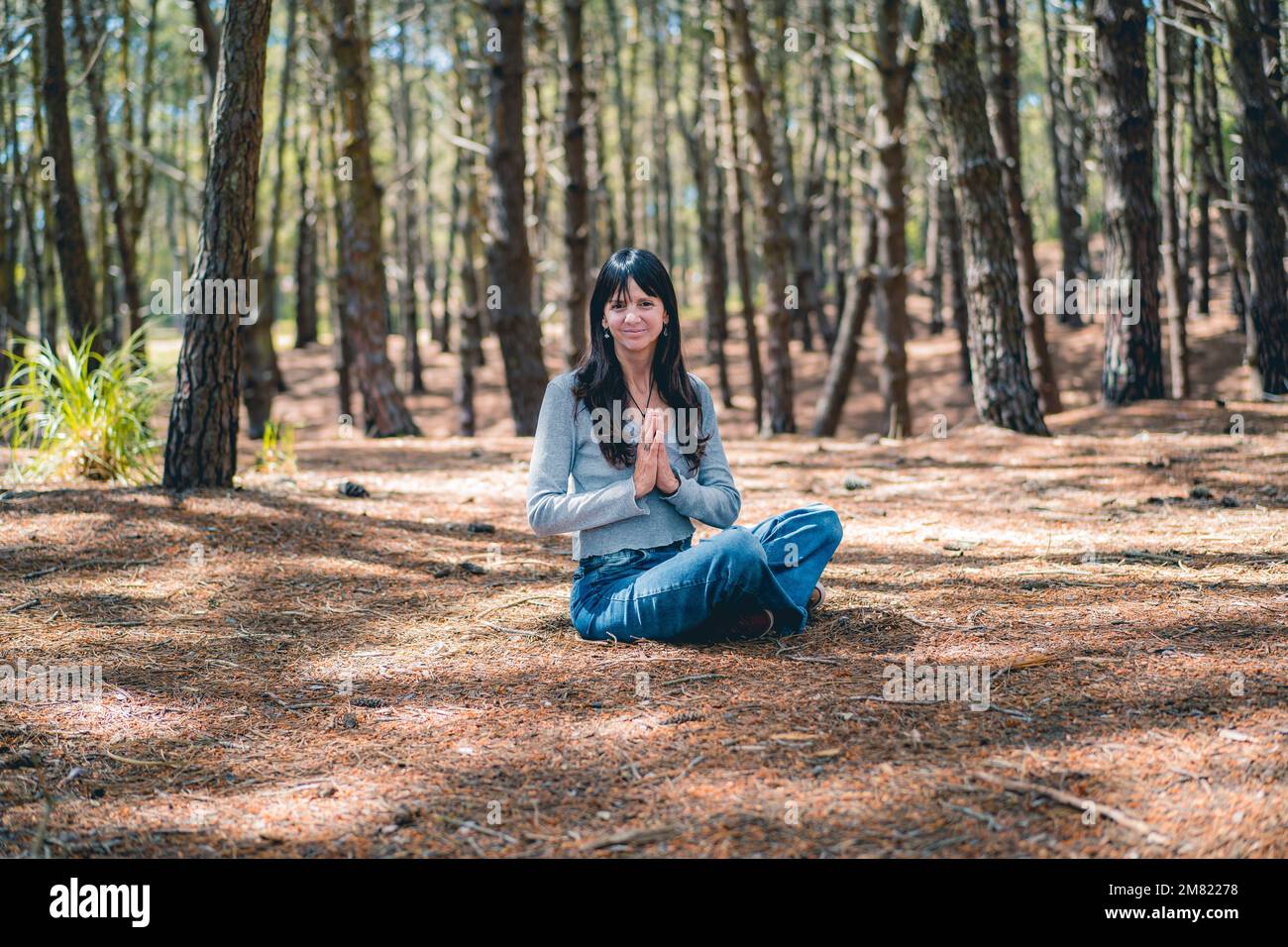 Eine Frau, die sich die Hände im Wald zusammenschlägt. Namaste-Pose. Stockfoto