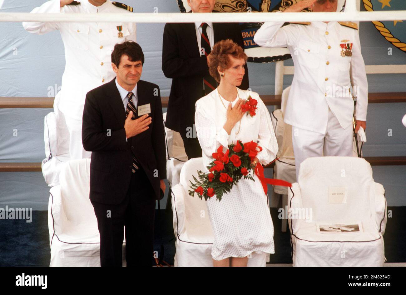 Bürgermeister Ted L. Wilson aus Salt Lake City, Utah, und Kathleen Brewerton Garn, Sponsor, stehen während der Zeremonie für das nuklearbetriebene Angriffs-U-Boot USS SALT LAKE CITY (SSN 716) für das Spiel der Nationalhymne. Flottillenadmiral Malcolm MacKinnon III., Supervisor of Shipbuilding, Conversion and Repair, Newport News, Virginia, Steht und salutiert. Basis: Norfolk Bundesstaat: Virginia (VA) Land: Vereinigte Staaten von Amerika (USA) Stockfoto