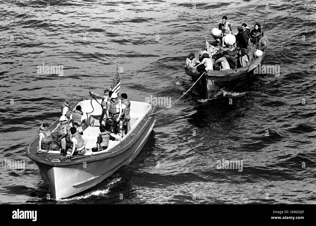 Ein Rettungsboot vom USS BLUE RIDGE (LCC 19) schleppt ein vietnamesisches Fischerboot zum amphibischen Kommandoschiff. 35 vietnamesische Flüchtlinge wurden 350 Meilen nördlich von Cam Ranh Bay, Vietnam, gerettet, nachdem sie acht Tage auf See verbracht hatten. Land: Südchinesisches Meer Stockfoto