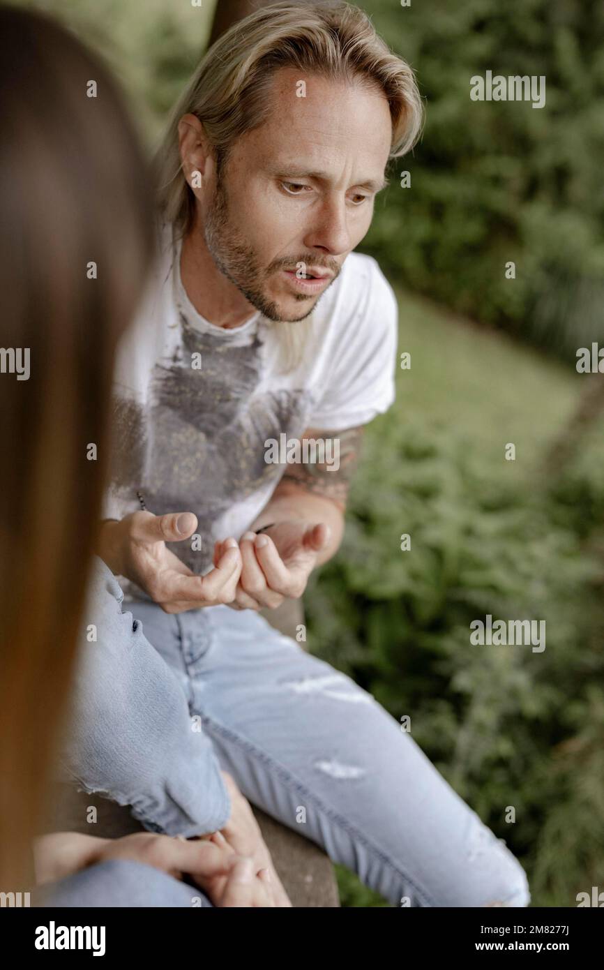 Tätowierter Mann, der mit einer Frau redet Stockfoto