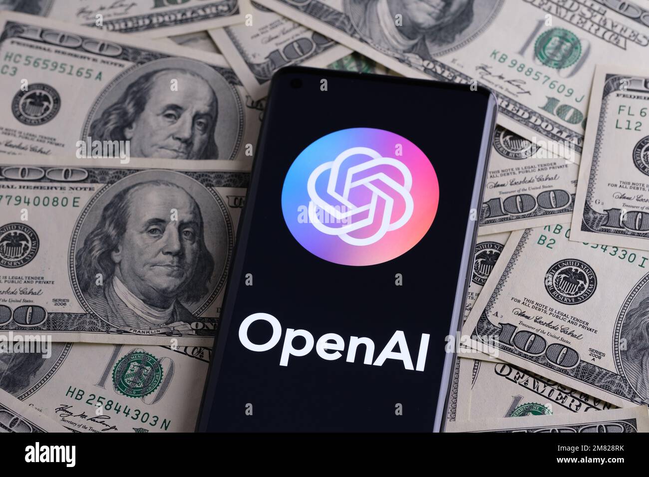 OPENAI wird auf dem Smartphone angezeigt, das auf einem Haufen Bargeld platziert wird. Open AI ist ein Unternehmen, das für seine generative ChatGPT- und DALL-E-AI-Software bekannt ist. Stafford, Stockfoto