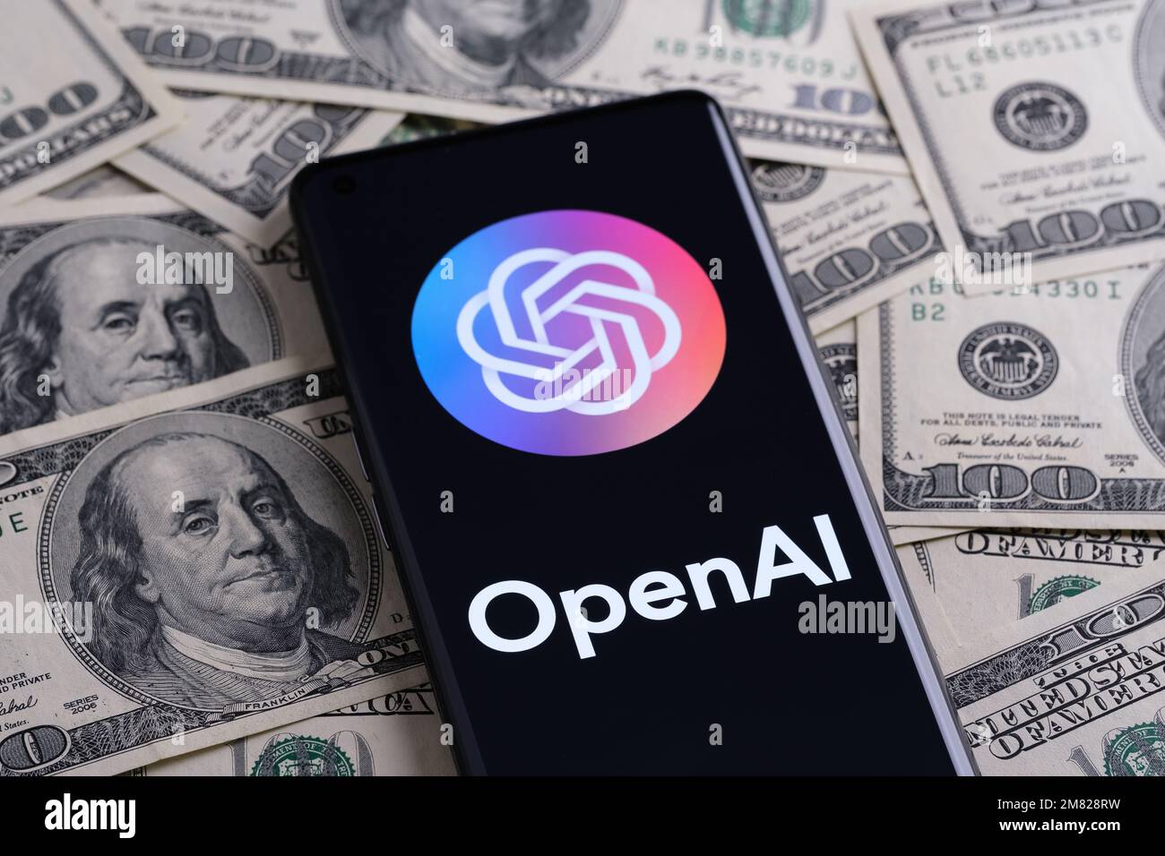 OPENAI wird auf dem Smartphone angezeigt, das auf einem Haufen Bargeld platziert wird. Open AI ist ein Unternehmen, das für seine generative ChatGPT- und DALL-E-AI-Software bekannt ist. Stafford, Stockfoto
