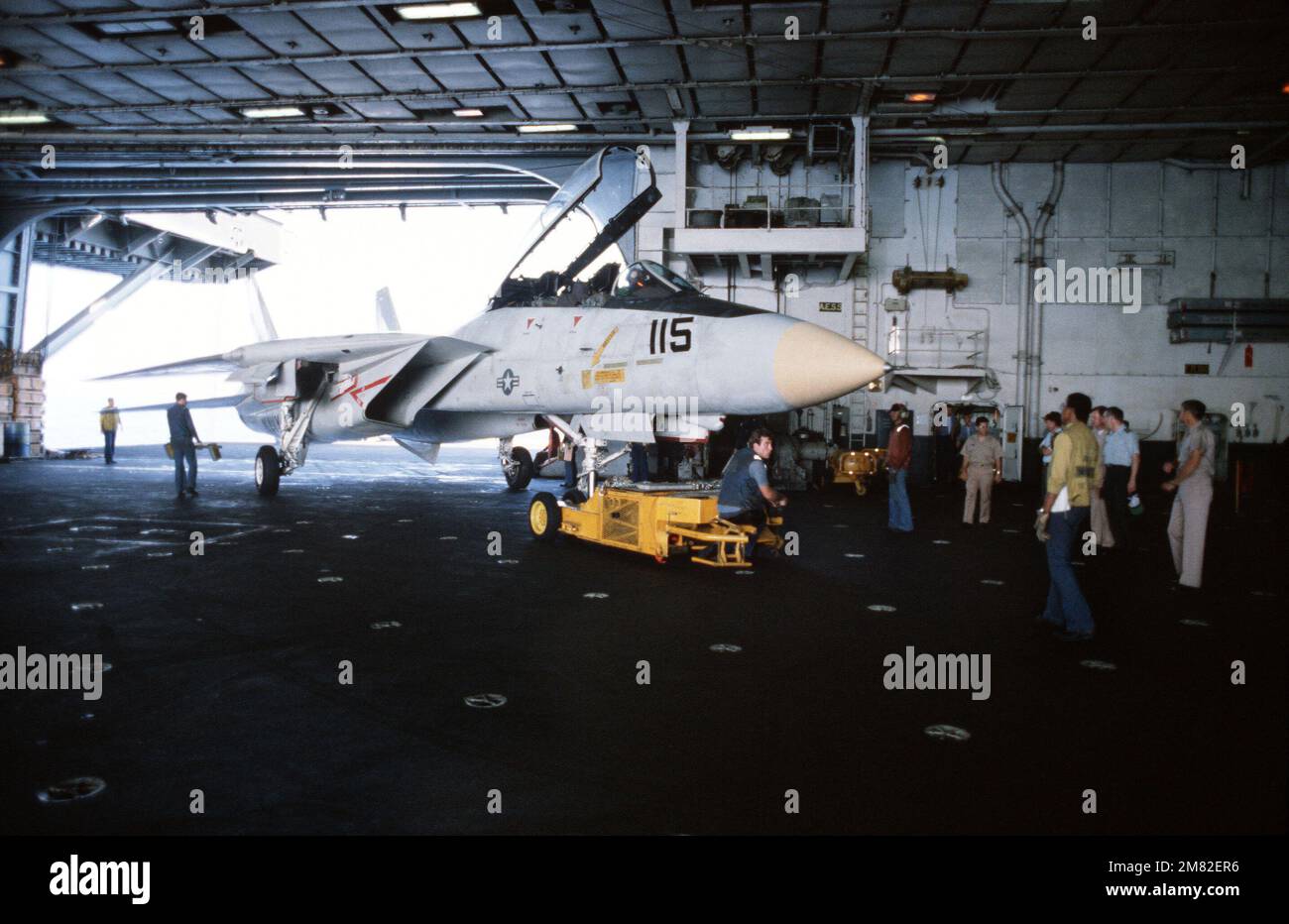 Ein SD-1D Spotting Dolly wird verwendet, um ein F-14A Tomcat Flugzeug in Hangarbucht Nr. 2 an Bord des Flugzeugträgers USS JOHN F. KENNEDY (CV 67) zu transportieren. Basis: USS John F. Kennedy (CV 67) Land: Atlantik (AOC) Stockfoto