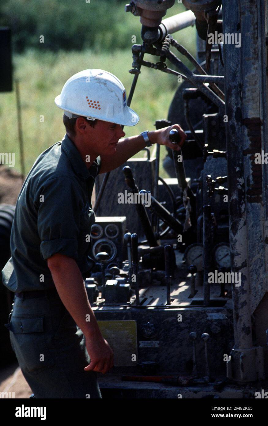 SGT. Mark Wagner, 865. Well Drilling Engineering det., steuert die Steuerung einer 1500-Fuß-Bohrmaschine während der Übung Gallant Eagle '84. Exaktes Datum Aufnahme Unbekannt. Betreff Operation/Serie: GALLANT EAGLE '84 Basis: Fort Irwin Bundesstaat: Kalifornien (CA) Land: Vereinigte Staaten von Amerika (USA) Stockfoto