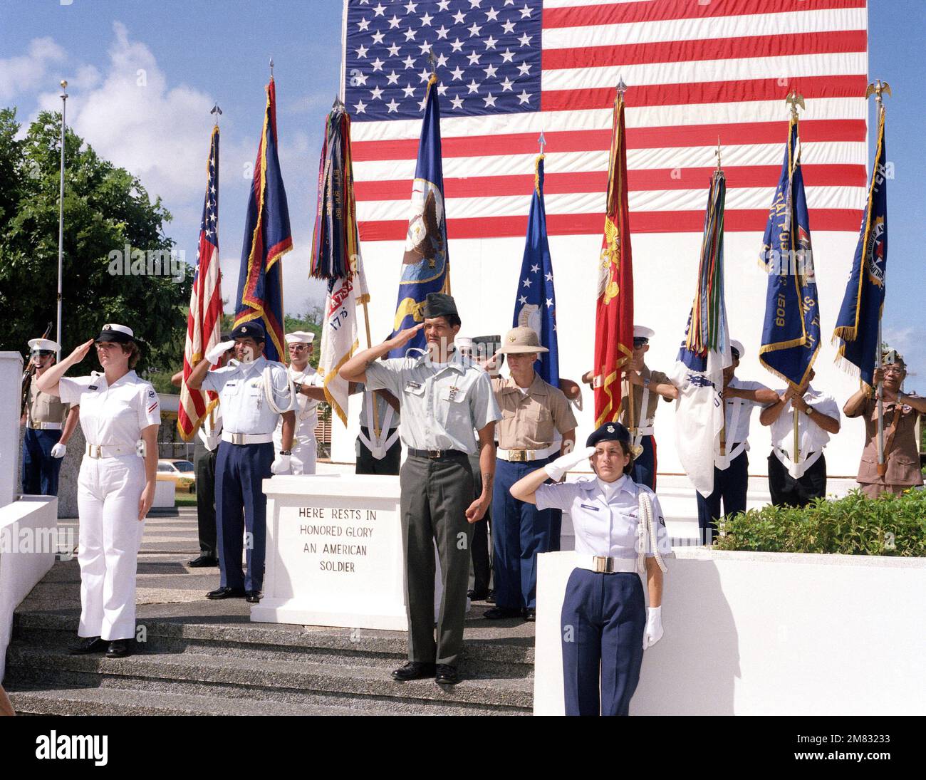 Mitglieder eines gemeinsamen Dienstes ehren den Wachsalut, während die Nationalhymne während einer Gedenkfeier zum Veteranentag im Grab des unbekannten Soldaten im Skinner Plaza gespielt wird. Staat: Guam Country: Nördliche Marianen (MNP) Stockfoto