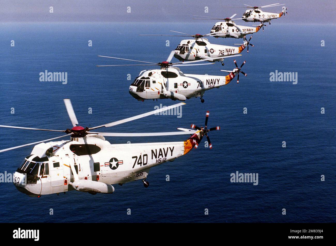 Air-to-Air-Seitenansicht von links von fünf SH-3 Sea King Anti-U-Boot-Hubschraubern der Helicopter Anti-U-Boot-Staffel 12 (HS-12), die in Formation fliegen. Land: Unbekannt Stockfoto