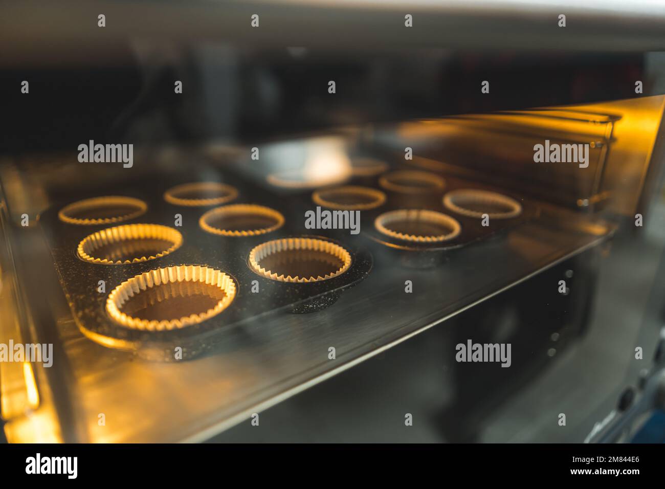 Nahaufnahme von Schokoladen-Muffins, die in einem Ofen gebacken werden, Süßigkeiten und Desserts. Hochwertiges Foto Stockfoto