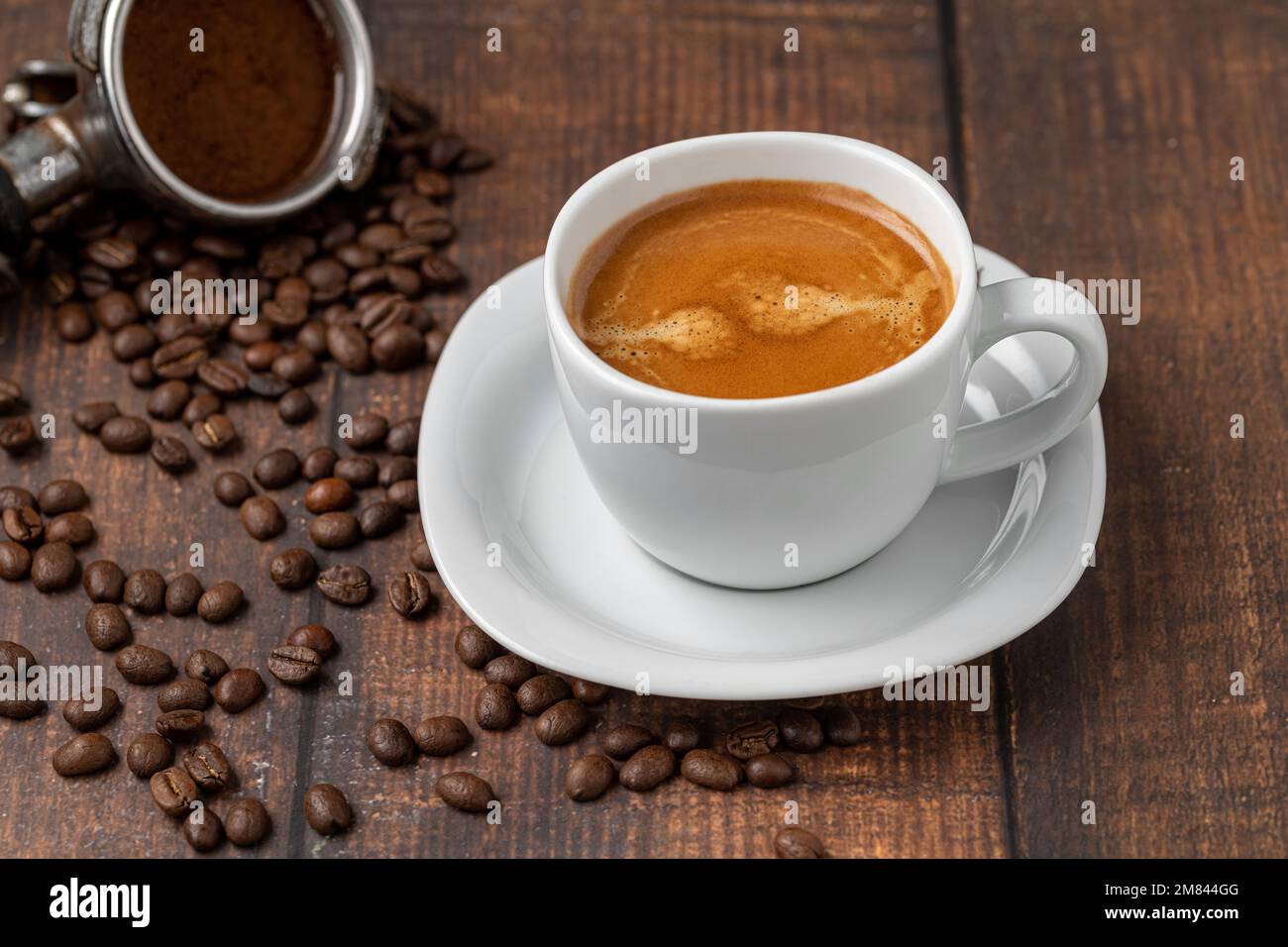 Frischer doppelter Espresso und Kaffeebohnen auf Holztisch Stockfoto