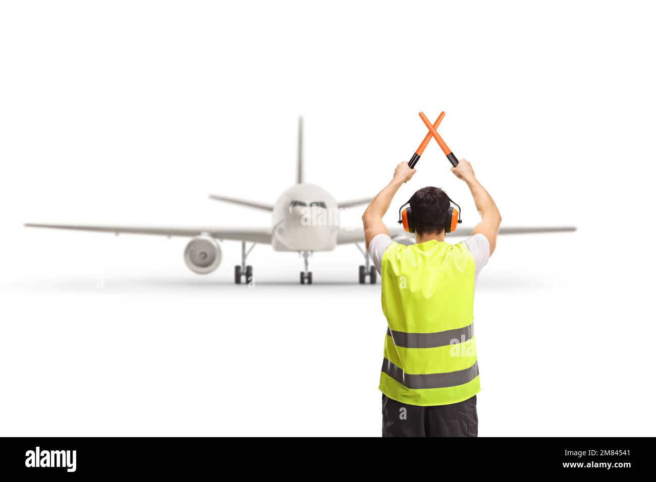 Rückansicht eines Marshallers mit gekreuzten Stäben vor einem Flugzeug, isoliert auf weißem Hintergrund Stockfoto