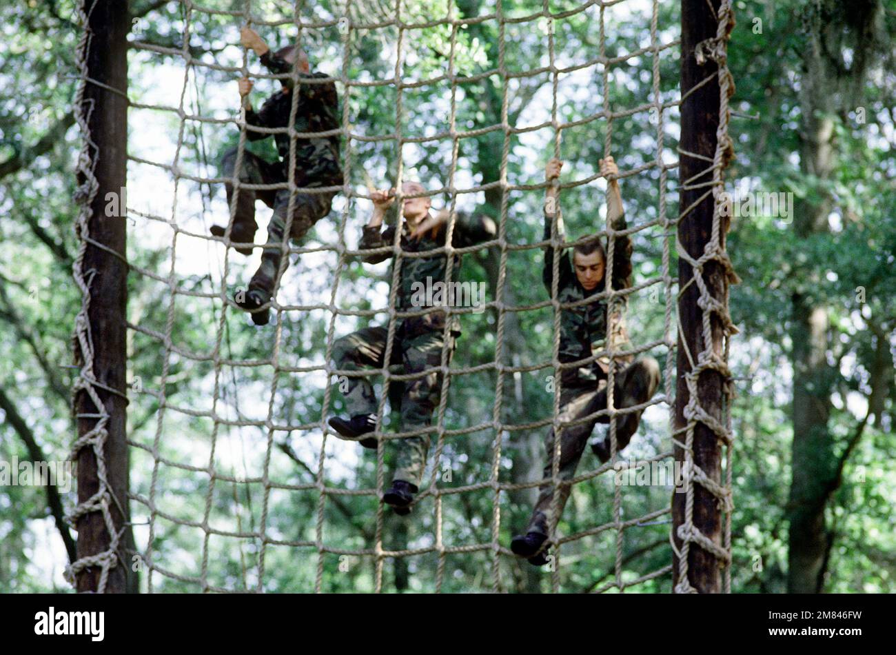 Rekruten klettern während der Grundausbildung im Rekrutierungslager des Marine Corps auf ein Frachtnetz. Basis: USMC Recruit Depot, Parris Island Bundesstaat: South Carolina (SC) Land: Vereinigte Staaten von Amerika (USA) Stockfoto