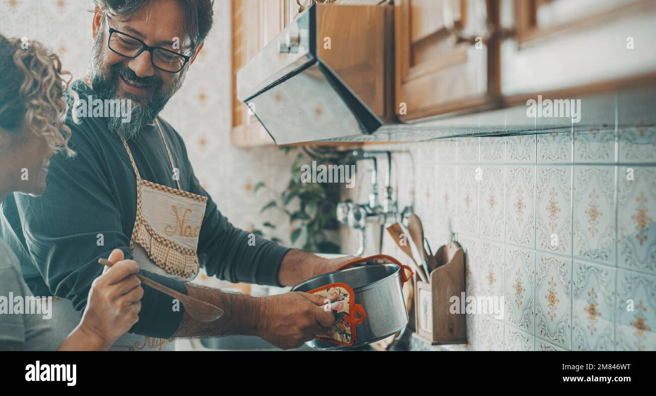 Mann und Frau bereiten Mittag- oder Abendessen zusammen in der Küche zu. Ein Paar, das zu Hause kocht und eine glückliche Beziehung genießt. Mann bereitet Essen zu und Frau Stockfoto
