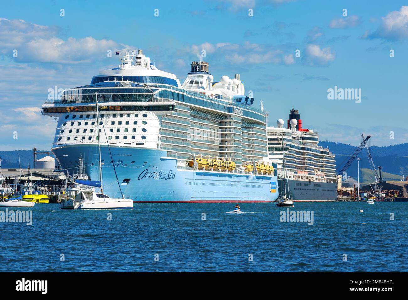 Zwei Kreuzfahrtschiffe, das Royal Caribbean Liner „Ovation of the Seas“ und die Cunard „Queen Elizabeth“ im Hafen. Mount Maunganui, Neuseeland Stockfoto