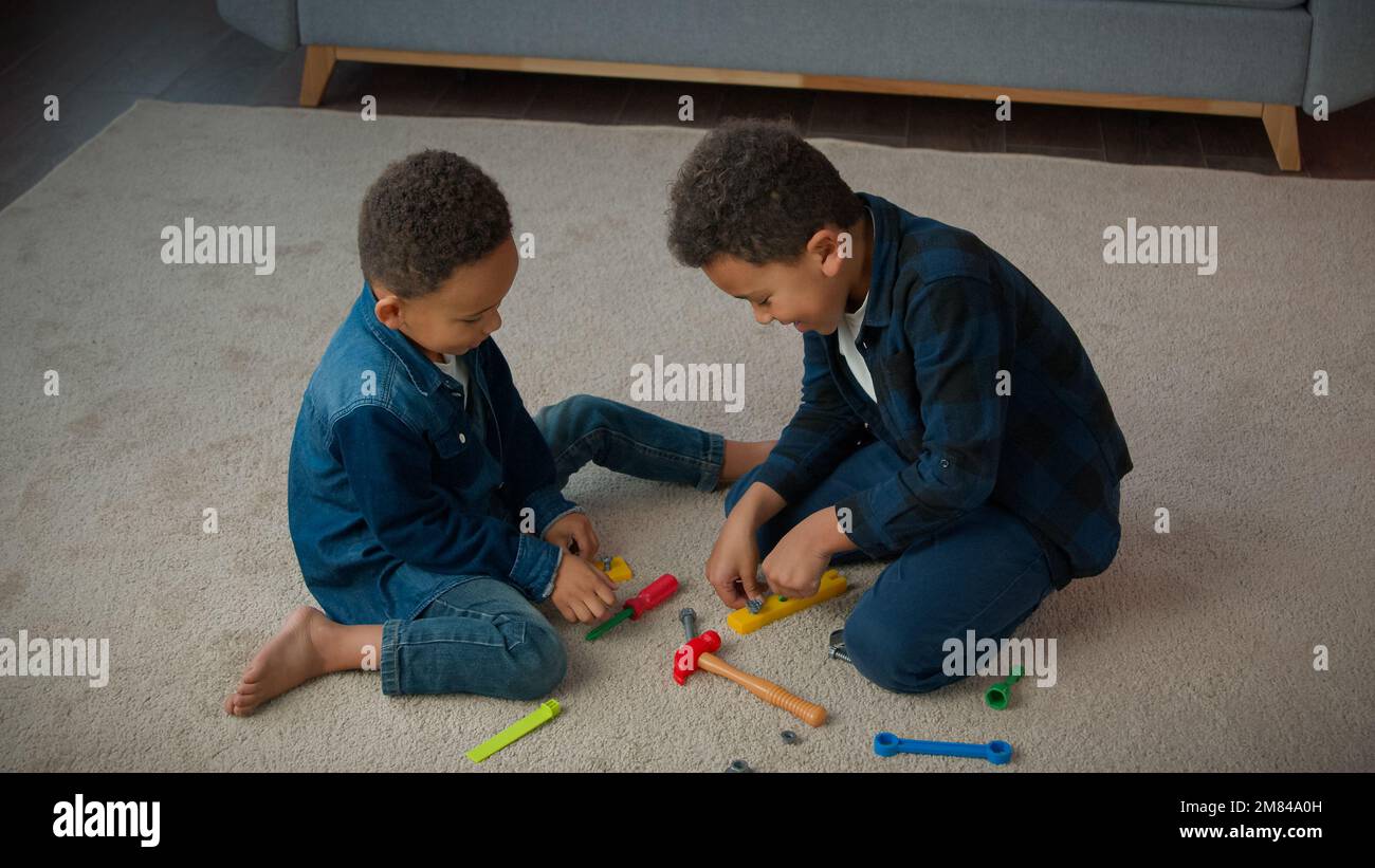 Ethnisch afroamerikanisch multiethnische Jungen Kinder Schuljungen Schüler Schüler Schüler Schüler Kinder Kinder Brüder Cousins Freunde Freunde auf dem Fußboden Stockfoto