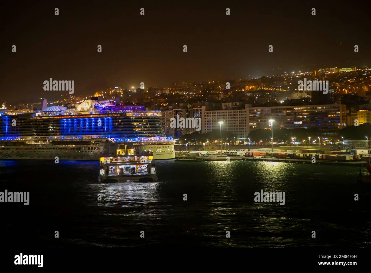 Trasmediterranea Fähre, die den Hafen mit dem Aida.de-Uhr-Kreuzfahrtschiff AIDAnova anlegt. Santa Cruz de Tenerife, Spanien, Kanarische Inseln, vor dem Westen der AFR Stockfoto