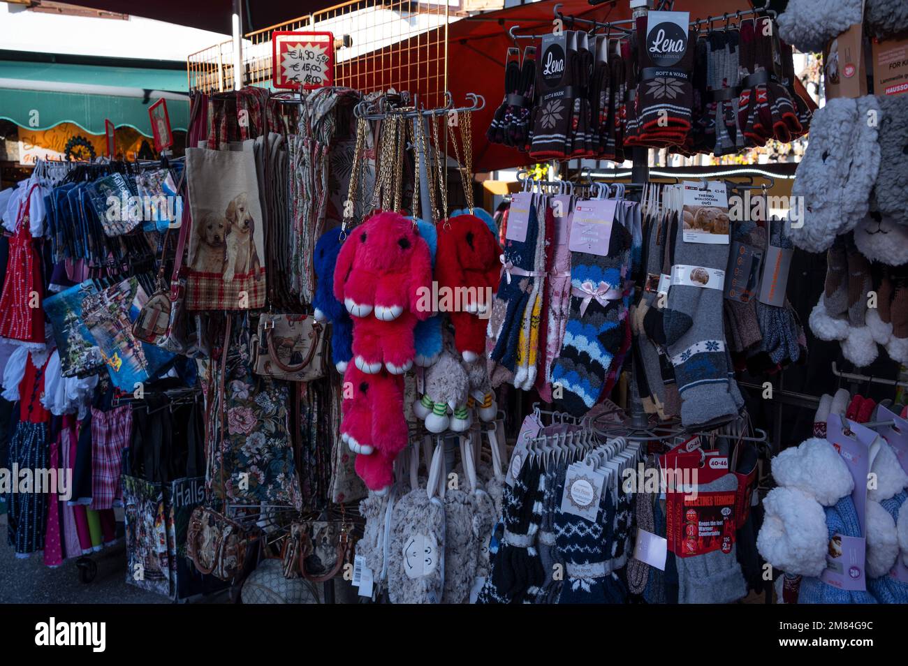 Blick auf einen Souvenirladen auf den Straßen, der Winterkleidung, bunte Magnete, Stoffspielzeug und Sammlerstücke verkauft, die in Hallstatt, Österreich, gefangen wurden. Stockfoto