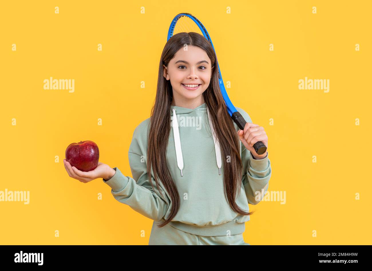 Teenager-Tennismädchen im Studio. Teenager-Tennis-Mädchen im Hintergrund. Foto von Teenager Tennis Girl mit Apfel. Stockfoto