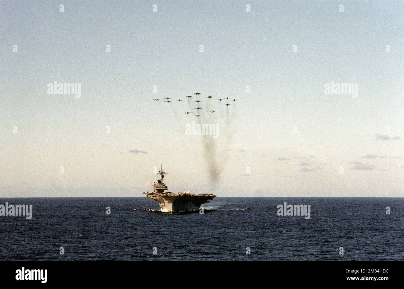 Eine Bogenansicht des Flugzeugträgers USS KITTY HAWK (CV-63), da verschiedene Luftfahrzeuge, die Carrier Air Wing (CVW-9) zugewiesen sind, in Formation über das Schiff fliegen. Land: Pazifik (POC) Stockfoto