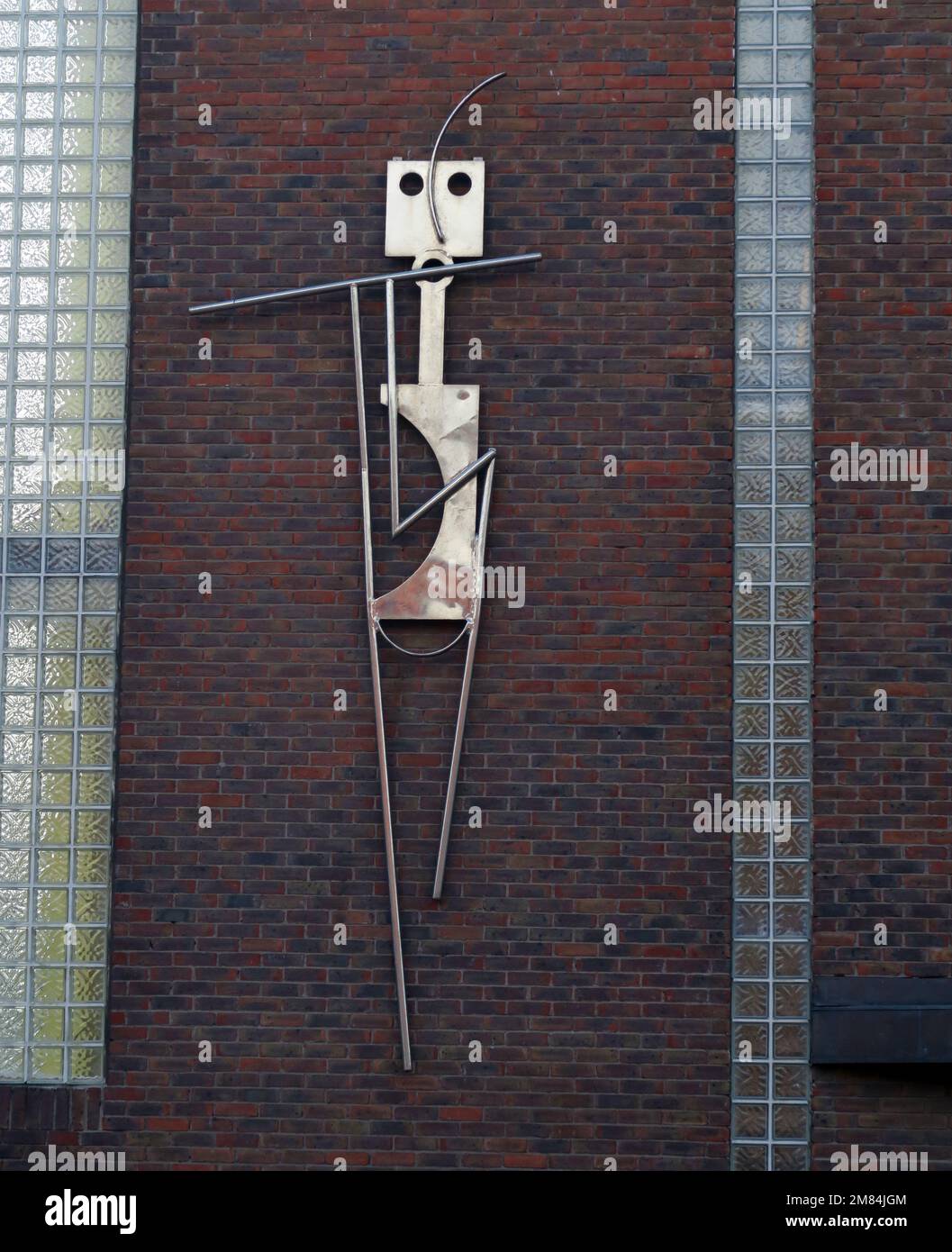 Metallkunst, eine Flöte spielende Figur, an einer Backsteinmauer befestigt, 8 King St N, Dublin, D07 X704, Eire, Irland Stockfoto