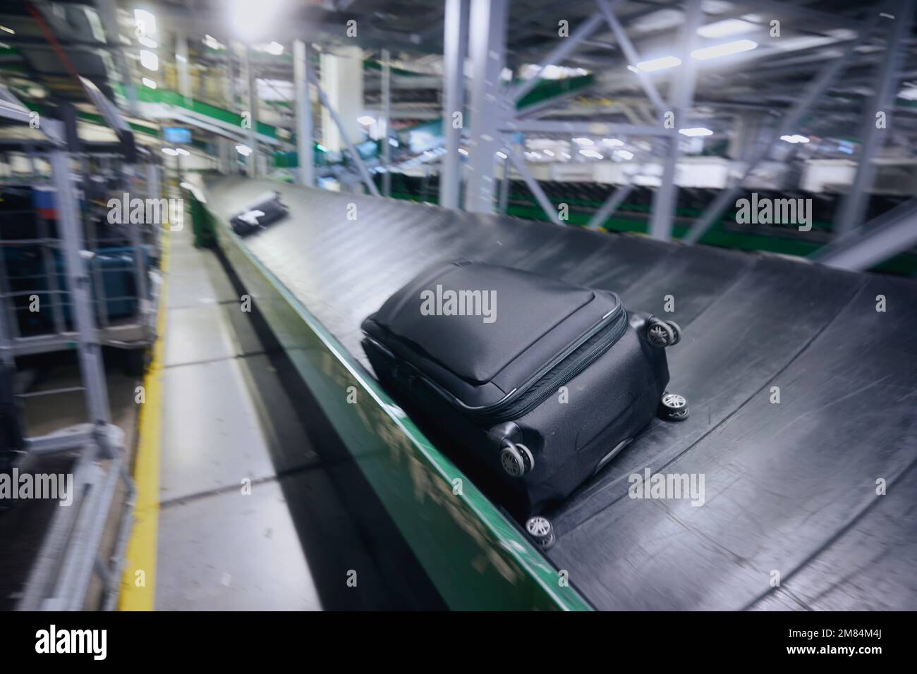 Reisen mit dem Flugzeug. Gepäck auf Förderband unscharf. Gepäcksortierung am Flughafen. Stockfoto