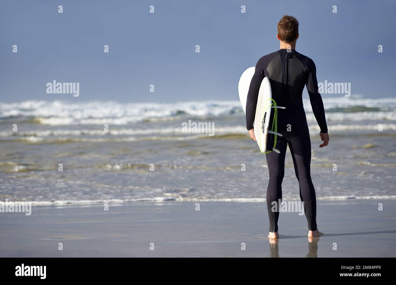 Bereit für die Wellen. Ein junger Mann, der surfen will. Stockfoto